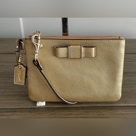 Coach Handbags - VGUC Coach Wristlet. Gold Saffiano Leather, Bow Accent